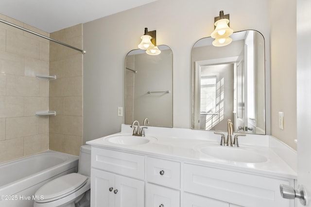 bathroom featuring a sink, bathing tub / shower combination, toilet, and double vanity