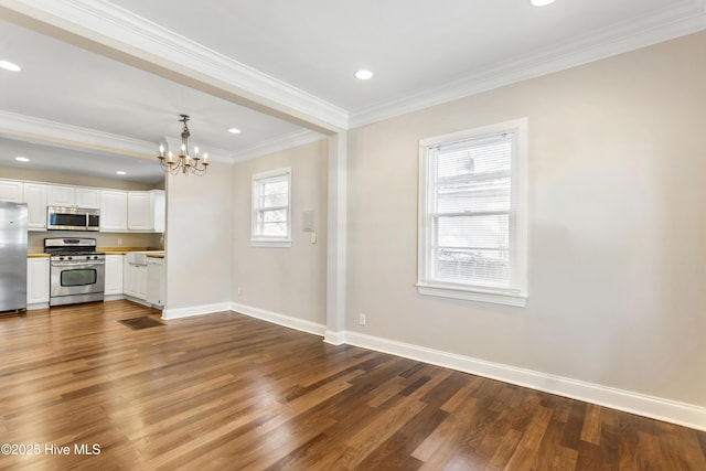 interior space with baseboards, stainless steel appliances, a notable chandelier, white cabinetry, and dark wood-style flooring