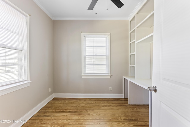 empty room featuring crown molding, baseboards, ceiling fan, and wood finished floors