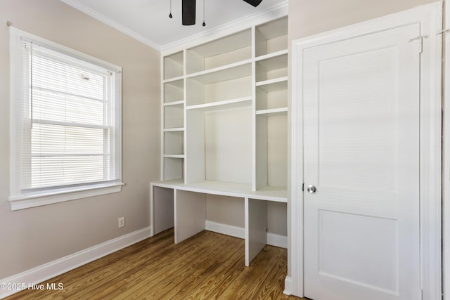 unfurnished office featuring ceiling fan, baseboards, ornamental molding, and wood finished floors