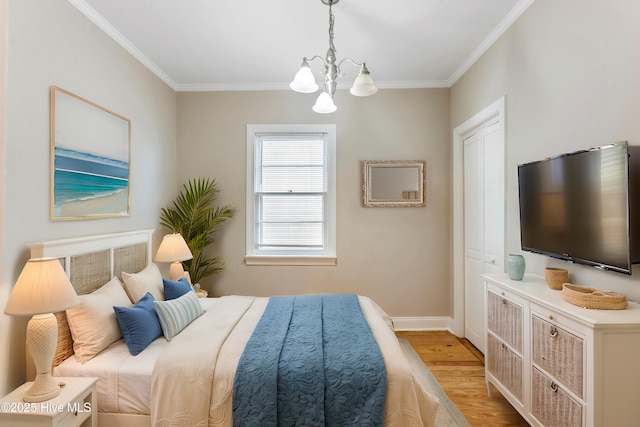 bedroom featuring an inviting chandelier, baseboards, crown molding, and wood finished floors