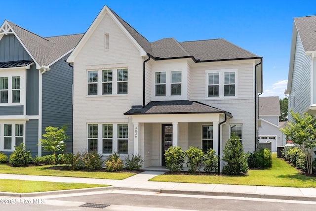 3836 Mason Port Dr, Wilmington, NC 28409 - view of front of house with brick siding, a shingled roof, a front yard, and covered porch