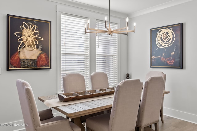 dining room with crown molding, an inviting chandelier, and hardwood / wood-style floors