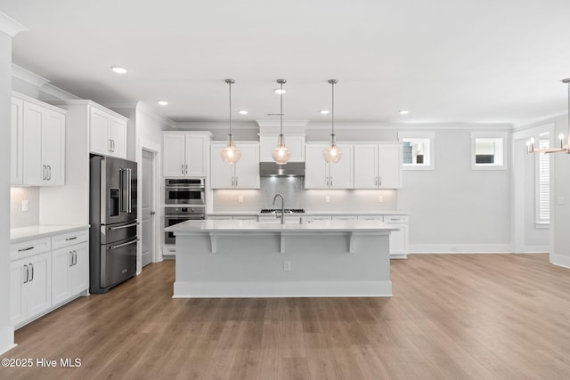 3836 Mason Port Dr, Wilmington, NC 28409 - kitchen with stainless steel appliances, light countertops, backsplash, light wood-style flooring, and range hood