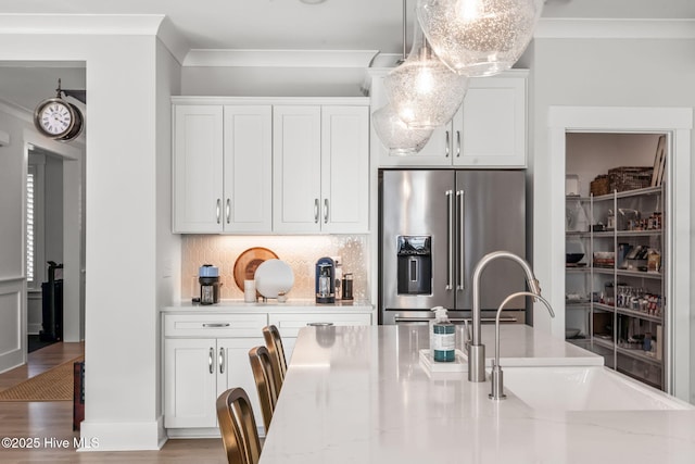 kitchen featuring white cabinetry, light stone countertops, and high end refrigerator