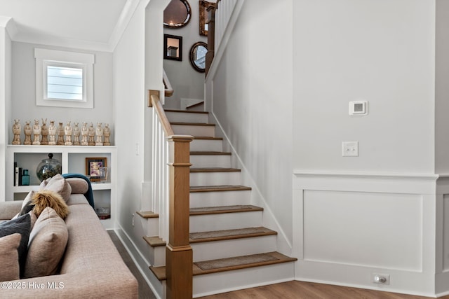 stairs with hardwood / wood-style floors and ornamental molding