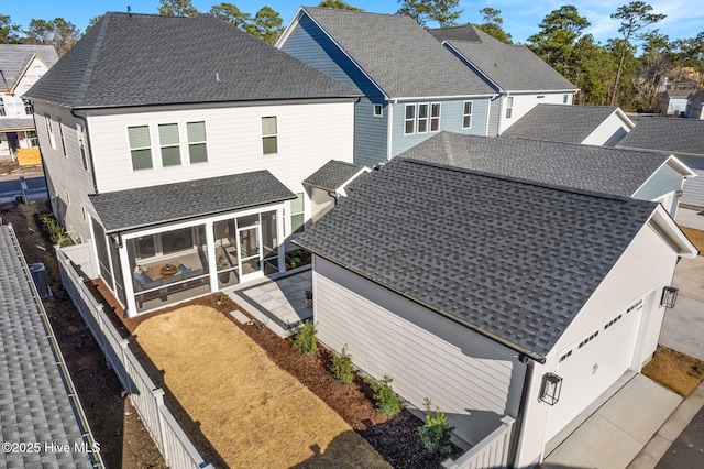 rear view of house with central AC, a garage, and a sunroom