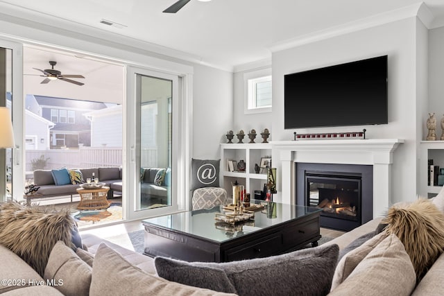 living room with crown molding and ceiling fan