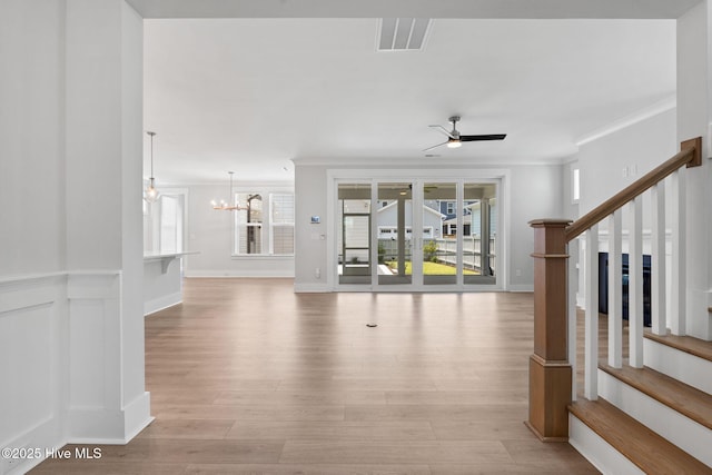 3836 Mason Port Dr, Wilmington, NC 28409 - unfurnished living room featuring stairs, a ceiling fan, light wood-style floors, a chandelier, and crown molding