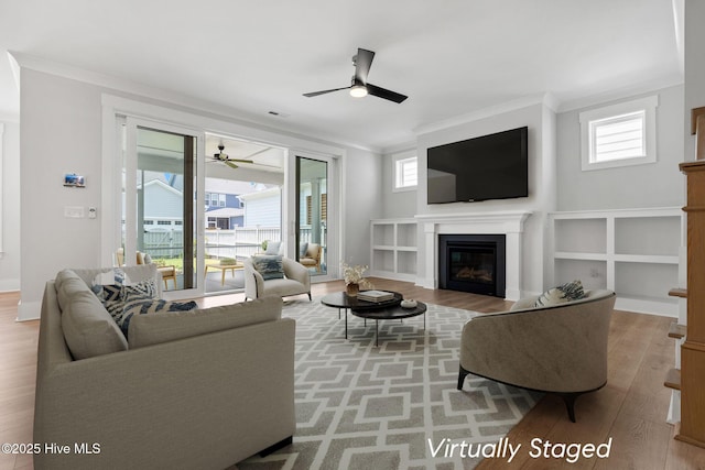 3836 Mason Port Dr, Wilmington, NC 28409 - living area with ceiling fan, crown molding, wood finished floors, and a glass covered fireplace
