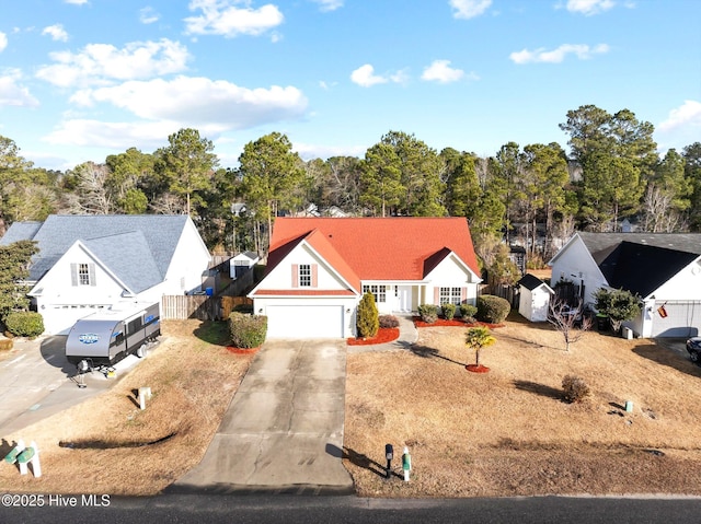 traditional home featuring concrete driveway, a storage unit, fence, and a garage