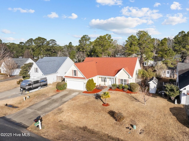 view of front of property with driveway, a garage, and fence