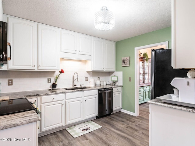 kitchen featuring dishwasher, sink, white cabinets, and a textured ceiling