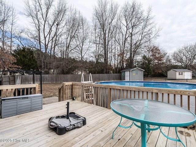 wooden deck featuring a fenced in pool and a storage unit