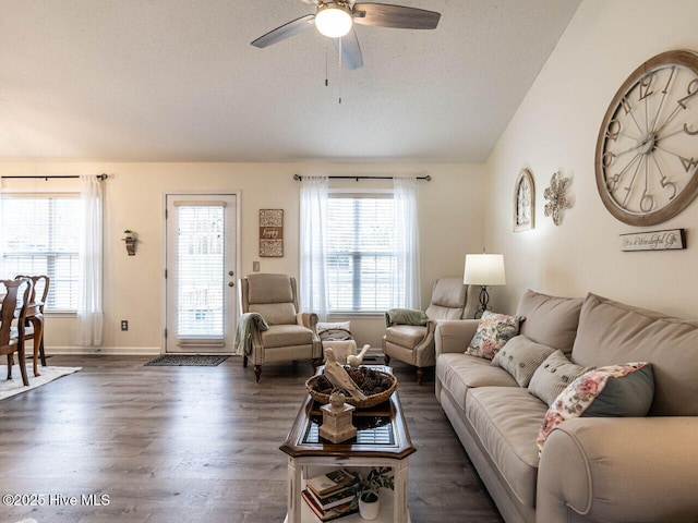 living room featuring dark wood-type flooring, plenty of natural light, ceiling fan, and vaulted ceiling