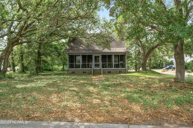 exterior space with a sunroom and a lawn