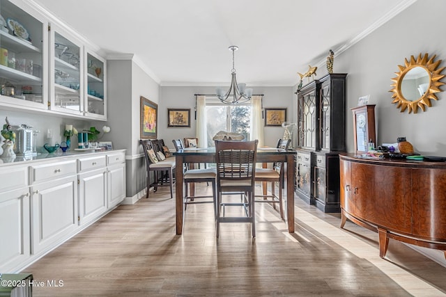 dining room with ornamental molding, a chandelier, and light wood-type flooring