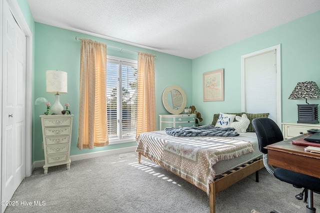 carpeted bedroom featuring a textured ceiling and a closet