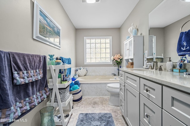 bathroom with vanity, a relaxing tiled tub, and toilet