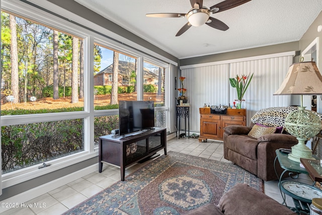 tiled living room with ceiling fan, a textured ceiling, and a healthy amount of sunlight