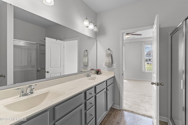 bathroom with vanity, wood-type flooring, an enclosed shower, and ceiling fan