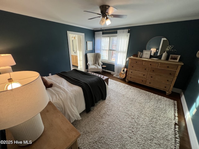 bedroom featuring ensuite bathroom, ornamental molding, dark wood-type flooring, and ceiling fan