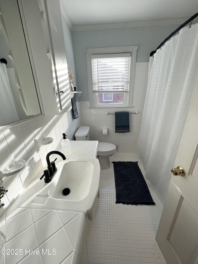 bathroom featuring sink, tile patterned flooring, tile walls, ornamental molding, and toilet