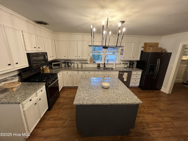 kitchen featuring sink, light stone counters, black appliances, white cabinets, and a kitchen island