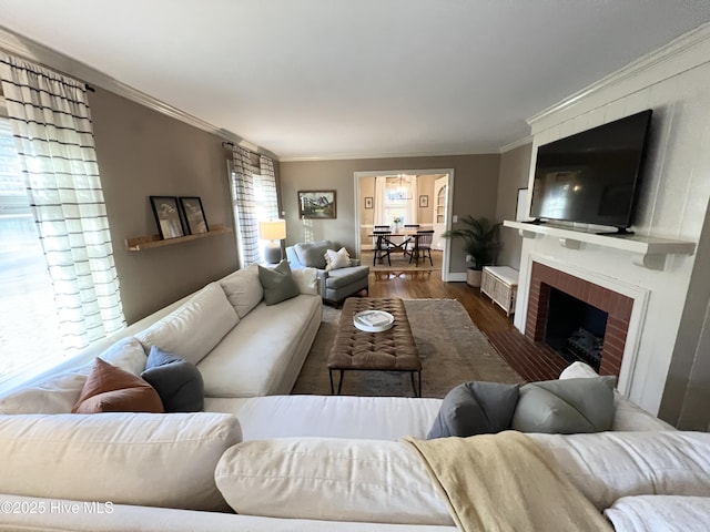 living room featuring hardwood / wood-style flooring, a fireplace, and crown molding