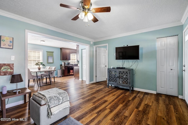 living room featuring ceiling fan, dark wood-type flooring, crown molding, and a textured ceiling