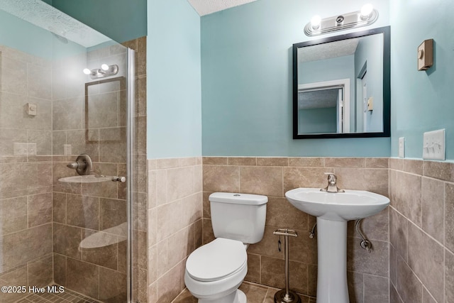 bathroom featuring tile walls, tiled shower, and toilet