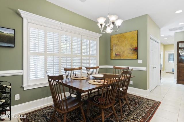 dining space featuring light tile patterned floors and a notable chandelier