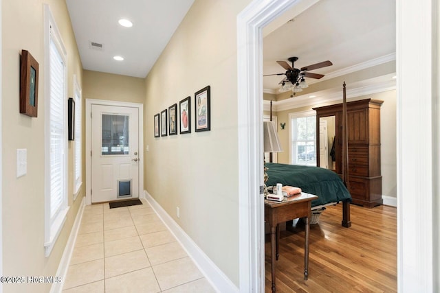 hall featuring crown molding and light tile patterned floors