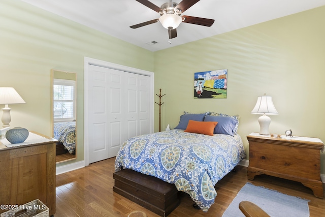 bedroom with dark wood-type flooring, a closet, and ceiling fan