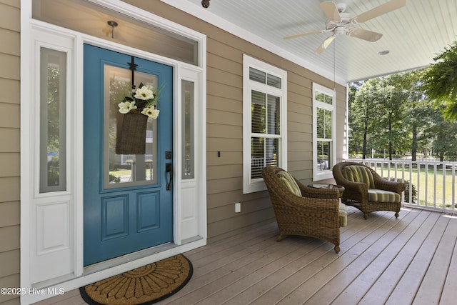 view of exterior entry with a porch and ceiling fan