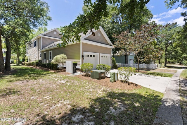 view of side of property featuring a garage and a lawn