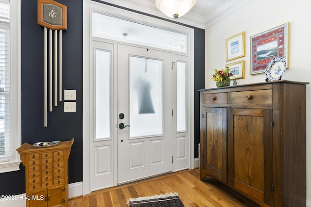 foyer with crown molding and light hardwood / wood-style flooring