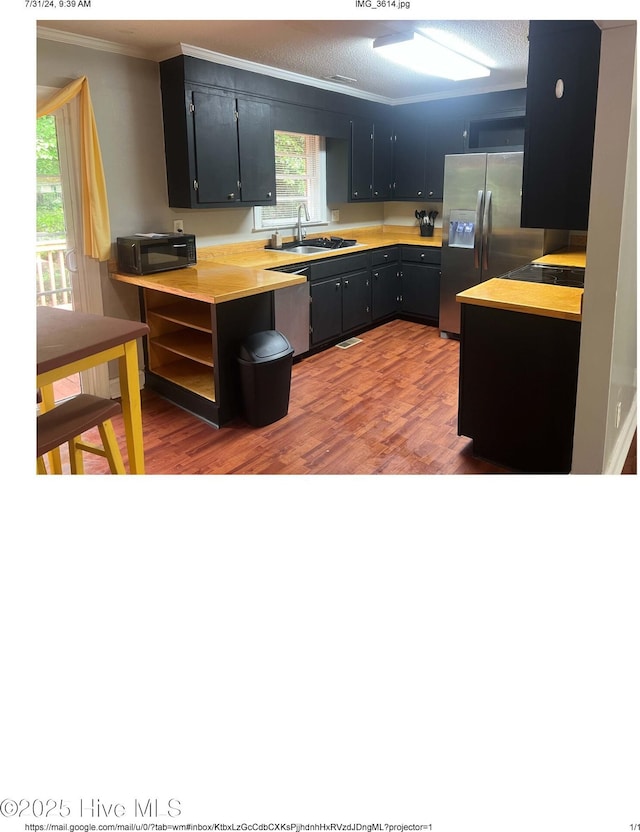 kitchen featuring appliances with stainless steel finishes, hardwood / wood-style floors, sink, ornamental molding, and a healthy amount of sunlight