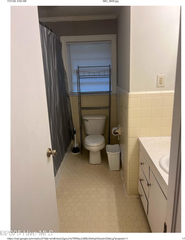 bathroom with vanity, tile patterned flooring, toilet, and tile walls