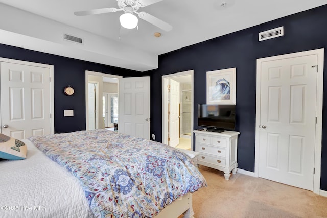 bedroom featuring ceiling fan, connected bathroom, and light carpet