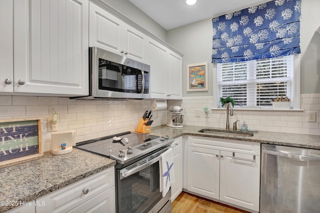 kitchen with white cabinetry, sink, and stainless steel appliances