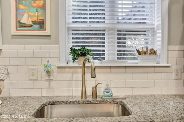 room details featuring light stone counters and sink