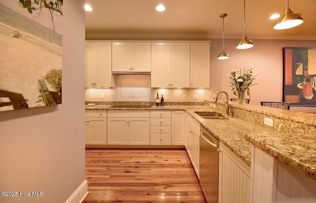 kitchen featuring sink, white cabinetry, hanging light fixtures, stainless steel dishwasher, and backsplash