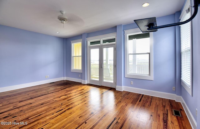 empty room featuring french doors and hardwood / wood-style floors