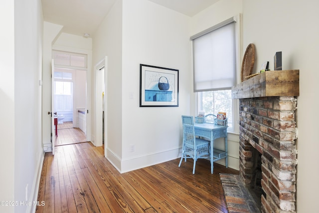 office area with a fireplace, baseboards, and hardwood / wood-style floors