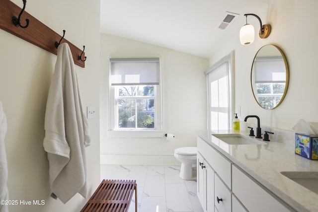 full bath featuring marble finish floor, lofted ceiling, visible vents, toilet, and a sink