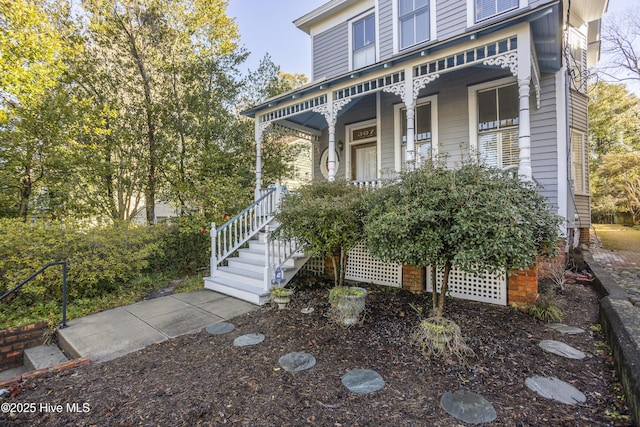 view of front facade featuring covered porch and stairway