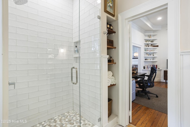 full bathroom featuring built in shelves, recessed lighting, wood finished floors, a shower stall, and crown molding