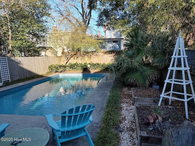 view of swimming pool featuring a garden, a fenced backyard, and a fenced in pool