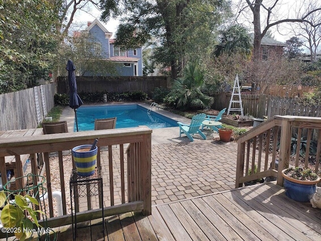 view of pool featuring a fenced in pool, a fenced backyard, a patio, and a deck